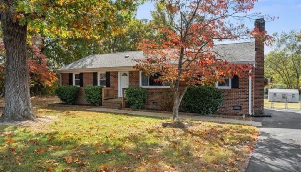 Brick ranch-style home in Midlothian, VA surrounded by autumn trees, showcasing seasonal home maintenance needs.